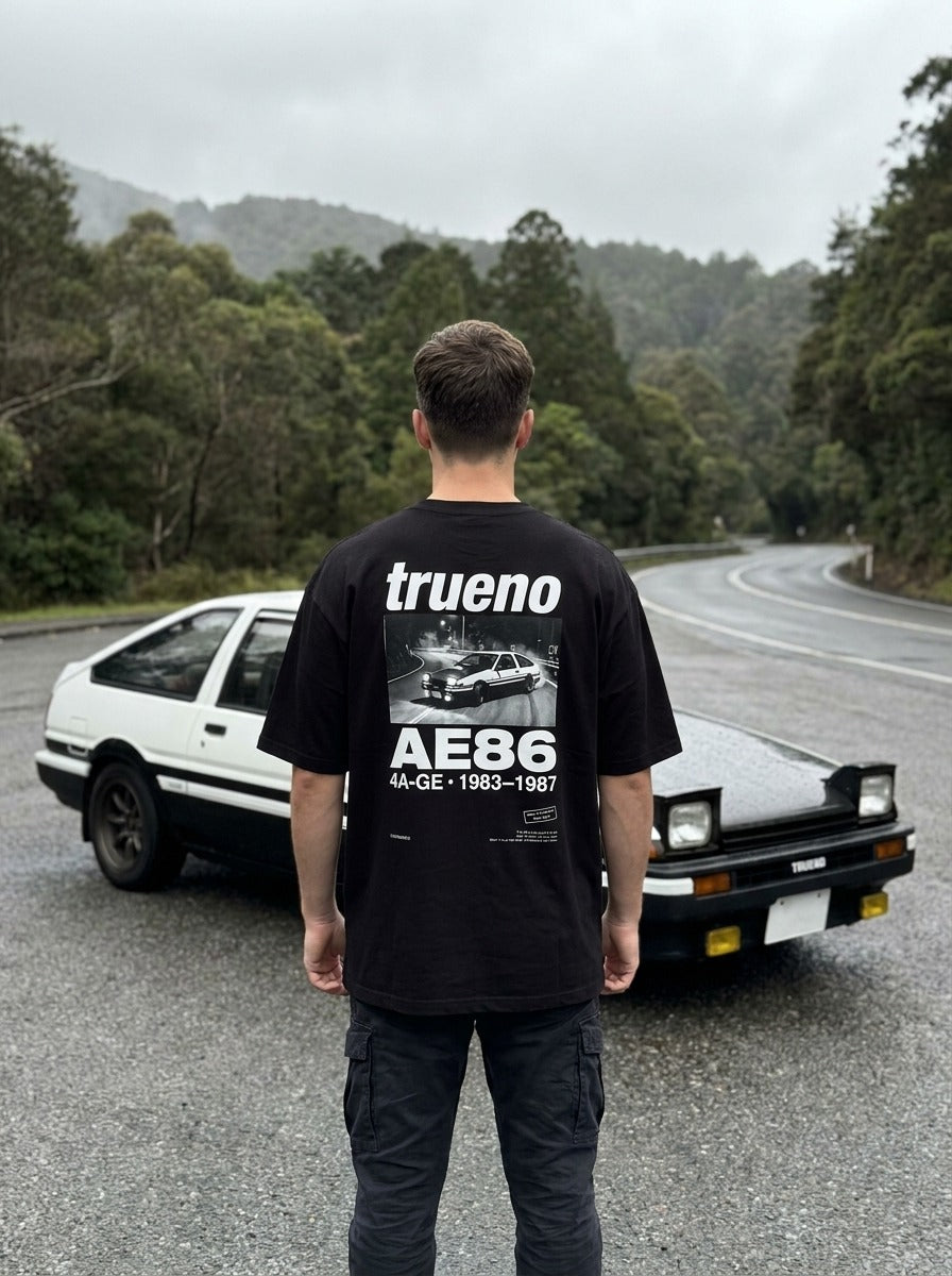T-shirt oversize Trueno AE86 noir porté de dos devant la voiture