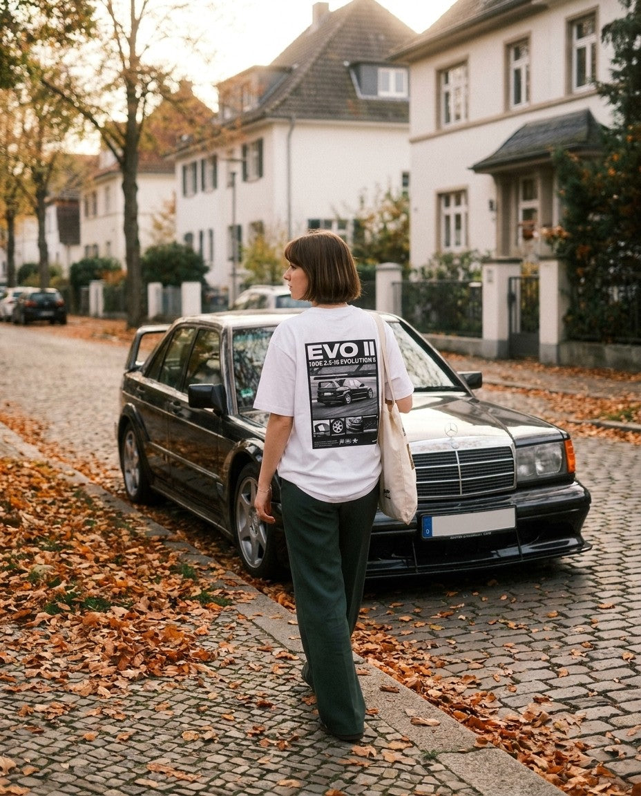 T-shirt Evo II porté dans une rue en automne à côté d'une 190E Evo II